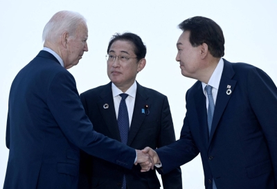 U.S. President Joe Biden, Prime Minister Kishida Fumio and South Korean leader Yoon Suk-yeol greet each other ahead of a trilateral meeting during the Group of Seven summit in Hiroshima on May 21.