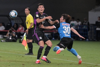 Bayern defender Kim Min-jae (center) and Frontale forward Yusuke Segawa (right) contend for the ball during an international friendly at the National Stadium on Saturday.