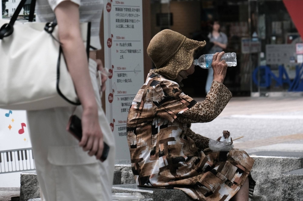 A woman drinks a bottle of water near Fukushima Station in the city of Fukushima on July 6.
