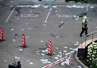 A firefighter walks among papers and broken glass Sunday outside a damaged office block of the Moscow International Business Center following a reported drone attack.