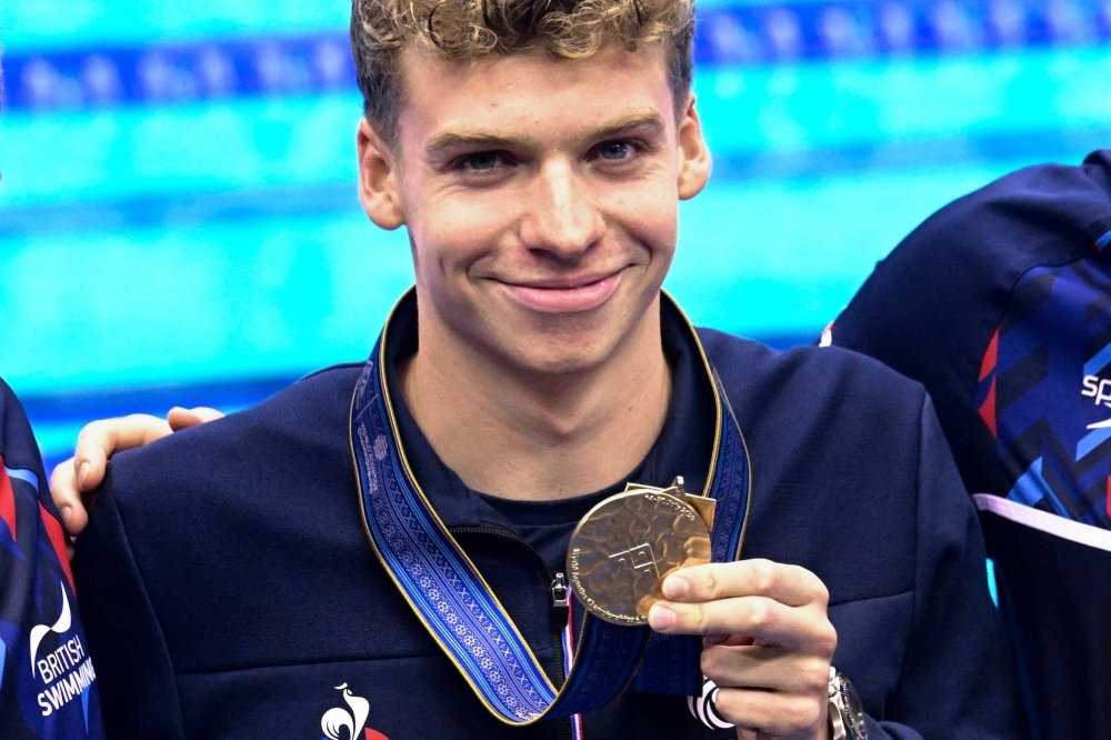 France's Leon Marchand poses with his gold medal after winning the men's 200-meter individual medley during the World Aquatics Championships in Fukuoka on Thursday.