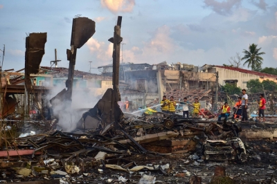Thai firefighters put out embers around destroyed homes after an explosion ripped through a firework warehouse, killing nine people and injuring more than 100 in the Sungai Kolok district. 