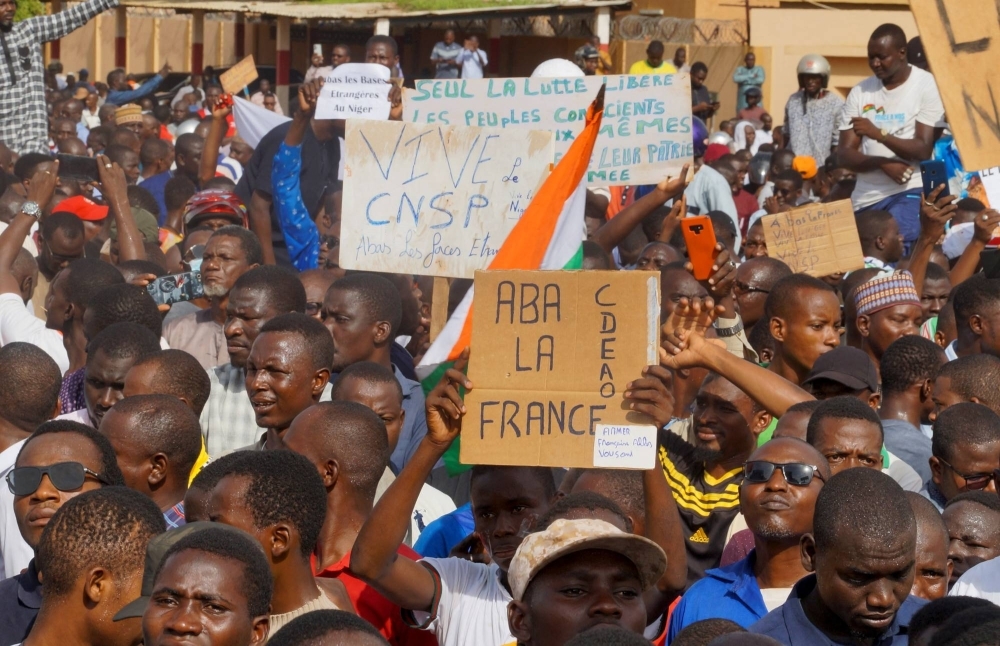 Demonstrators gather in the capita Niamey, Niger, on Sunday. Signs read "long live CNSP," "down with France, ECOWAS."