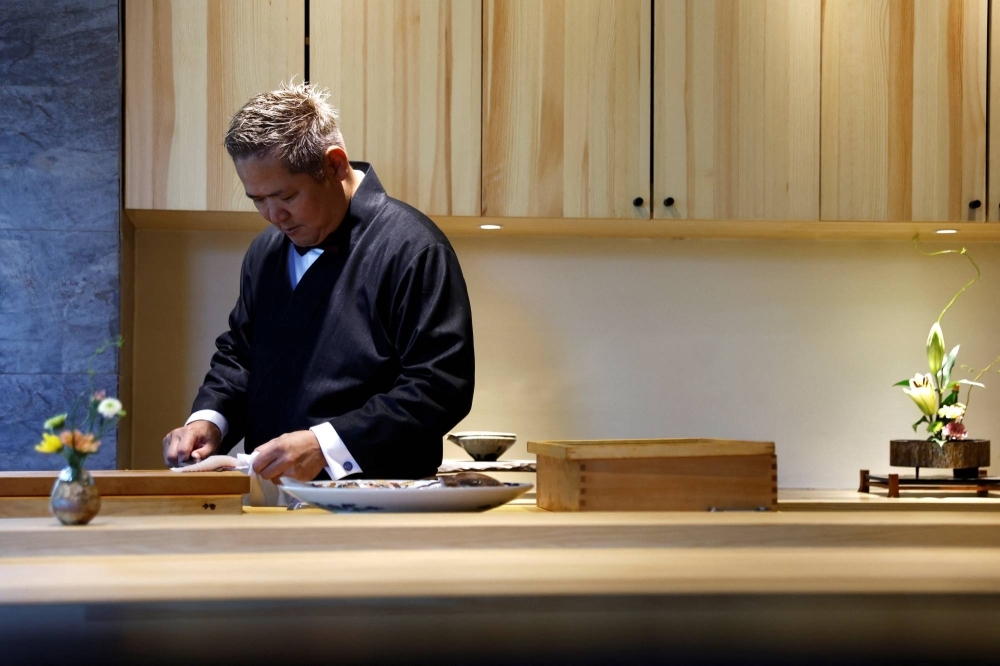 Kazuyuki Tanioka, the owner of Japanese cuisine Toya restaurant, prepares fish a sashimi dish during an interview in Beijing on July 25.