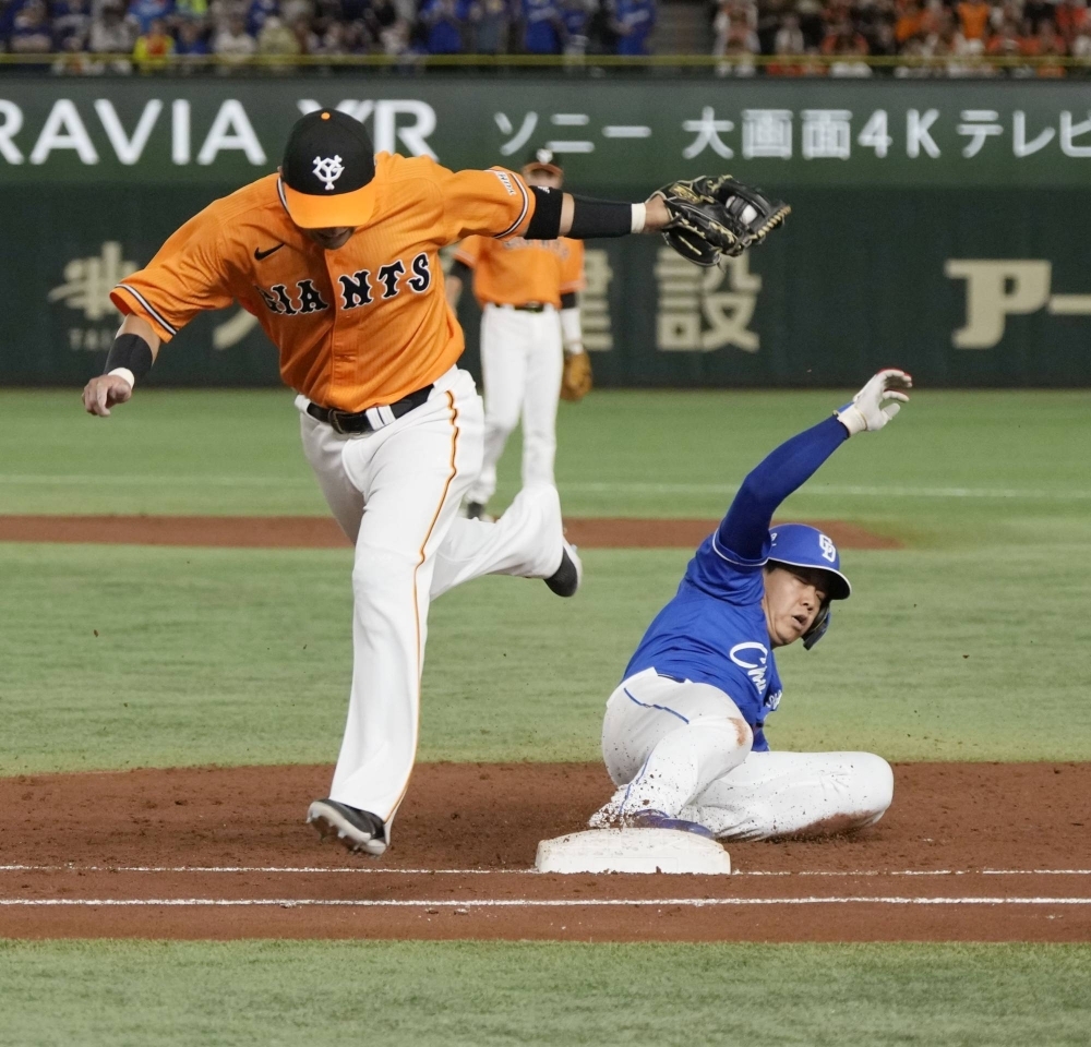 The Giants' Naoki Yoshikawa (left) records an out at first base during his team's win over the Dragons at Tokyo Dome on Sunday.