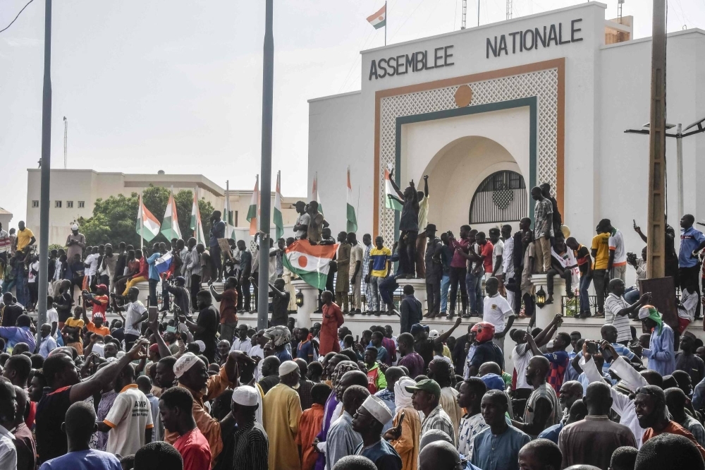 Supporters wave flags as they rally in support of Niger's junta in front of the National Assembly in Niamey on Sunday.