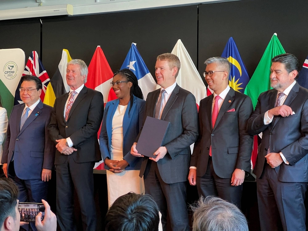 New Zealand Prime Minister Chris Hipkins (center) and others, as Britain signs the treaty to join the Comprehensive and Progressive Agreement for Trans-Pacific Partnership, in Auckland on July 16.