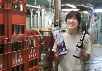 Chikako Utsumi holds bottles of Rose Mind at Tenpoichi sake brewer in Fukuyama, Hiroshima Prefecture.