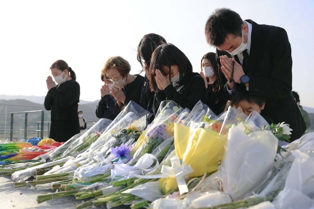 People pray in the city of Rikuzentakata, Iwate Prefecture, on March 11 this year, the 12th anniversary of the earthquake, tsunami and nuclear disaster that devastated the country's northeast.