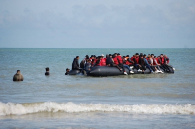 Migrants sit onboard an inflatable boat before attempting to illegally cross the English Channel to reach Britain, off the coast of Sangatte, northern France, on July 18.