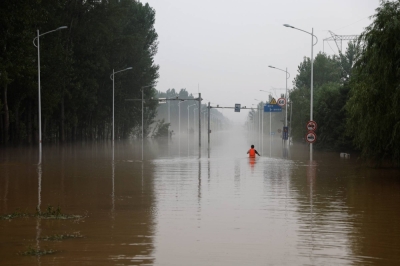 A man makes his way through a flooded road after the rains and floods brought by remnants of Typhoon Doksuri, in Zhuozhou, Hebei province, China, on Thursday.