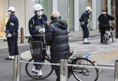 Police officers call on cyclists to drive safely in the city of Osaka in January.   Kyodo