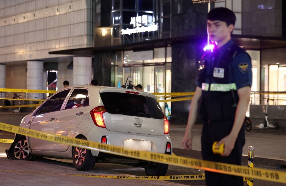 A policeman stands next to a scene where several people have been stabbed and others hurt in Seongnam, South Korea, on Thursday.