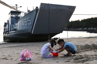 Children play on a beach near a Taiwan Navy supply ship on Nangan Island, which is part of the Matsu Archipelago that is controlled by Taipei and located close to the coast of mainland China.