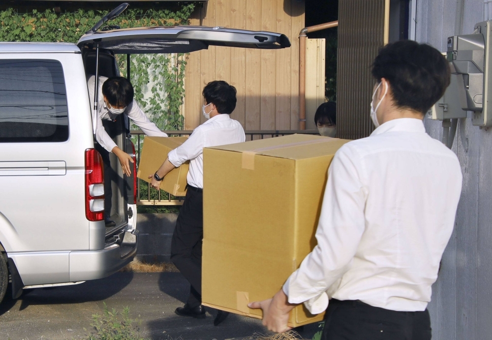 Officials from the Tokyo District Public Prosecutors Office remove seized items from the office of Liberal Democratic Party Lower House lawmaker Masatoshi Akimoto in Sakura, Chiba Prefecture, on Friday.