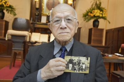Ryuzaburo Mizuno, who was born in Brazil seven years after the Great Kanto Earthquake, holds a photo of his family. 