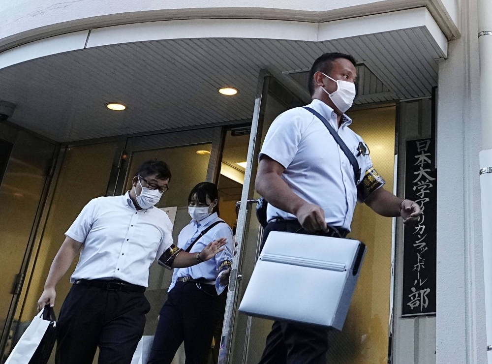 Police leave the dormitory of Nihon University's American football team in Tokyo after finishing the search on Thursday. 