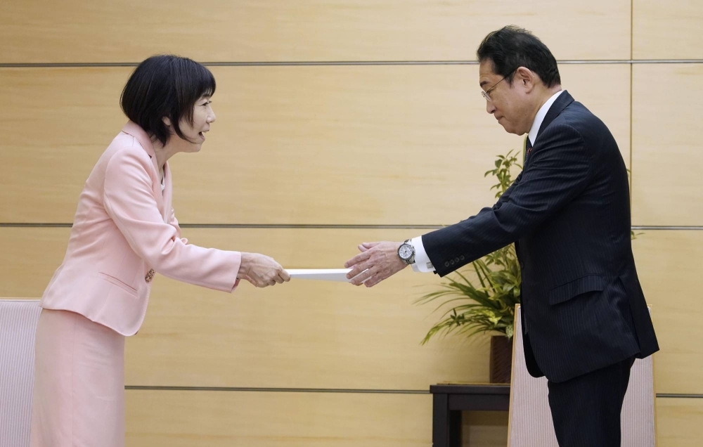 Yuko Kawamoto, president of the National Personnel Authority, hands a proposal to Prime Minister Fumio Kishida at the prime minister's official residence in Tokyo on Monday.