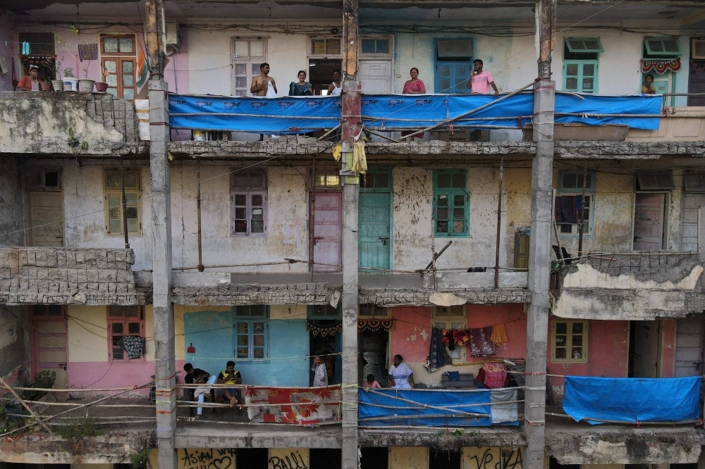 Residents stand in the corridors outside their homes at the Worli dairy quarters building in Mumbai. This crumbling structure houses more than 600 people.