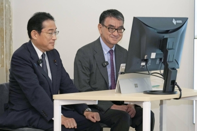 Prime Minister Fumio Kishida (left) and Digital Minister Taro Kono observe digitized administrative procedures in the city of Fukuoka on July 27.
