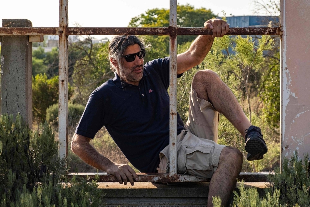 Cypriot researcher and urbex enthusiast Christos Zoumides climbs a fence into an abandoned amusement park in Nicosia, Cyprus.