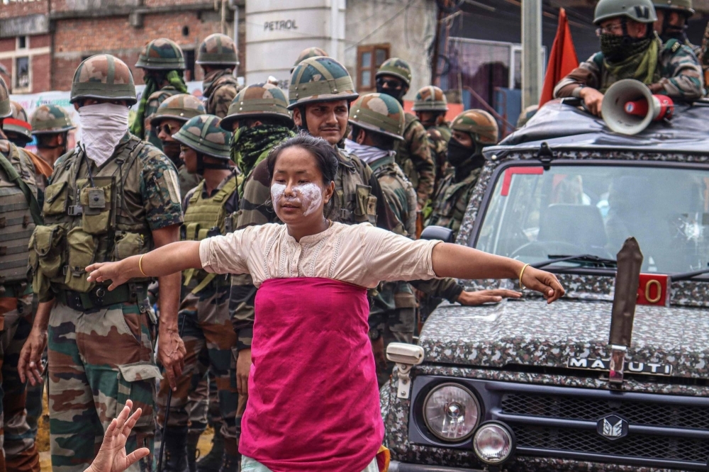 A demonstrator blocks a military vehicle in the city of Imphal on Aug. 3 during a protest against the killings of Kuki peoples amid ethnic violence in the Indian state of Manipur.