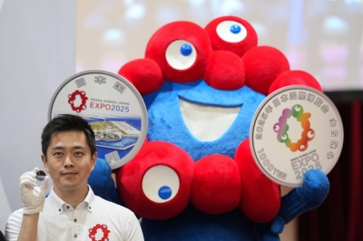 Osaka Gov. Hirofumi Yoshimura attends a ceremony marking the first minting of a commemorative coin for the expo with the event's mascot, Myaku-Myaku, in Osaka on Monday.