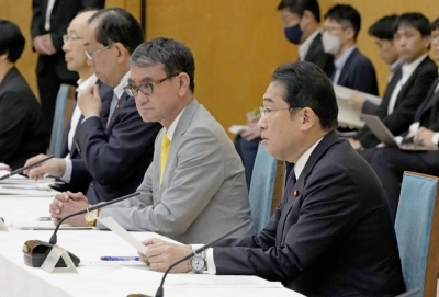 Japanese Prime Minister Fumio Kishida (right) sits next to digital minister Taro Kono while speaking at a government review meeting on the My Number national identification cards.