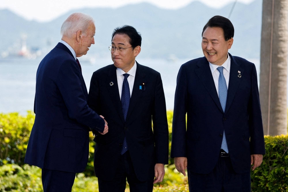 U.S. President Joe Biden (left), Prime Minister Fumio Kishida (center) and South Korea’s President Yoon Suk-yeol attend a photo op on the day of trilateral engagement during the G7 Summit in Hiroshima in May.