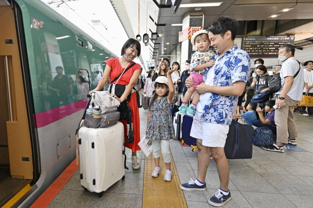 People board a shinkansen at Tokyo Station on Friday