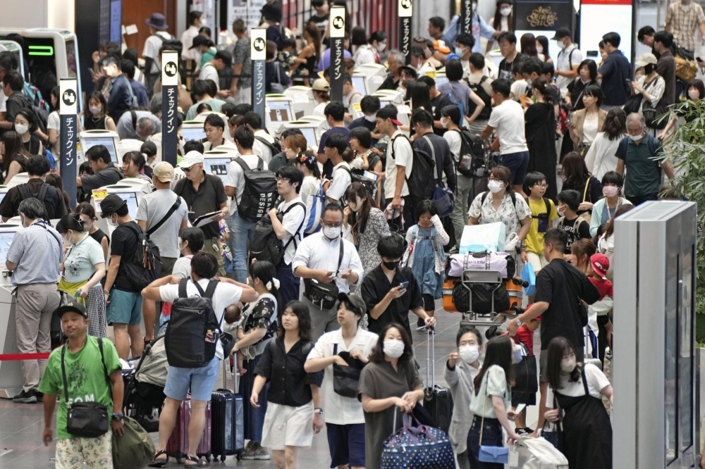 Travelers flock to Tokyo's Haneda Airport on Friday morning.