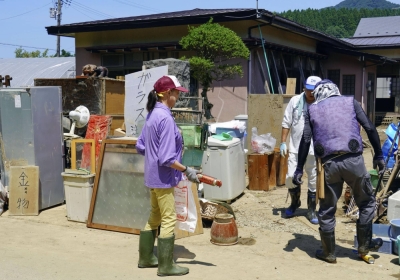 Residents of Gojome, Akita Prefecture, clear disaster debris on July 22 after their houses were flooded by torrential rains.