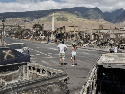 People surveying wildfire damage in the town of Lahaina in Hawaii on Friday. Emergency workers on Saturday continued to dig through the ash and rubble, with the official death toll from the fires rising to 93.