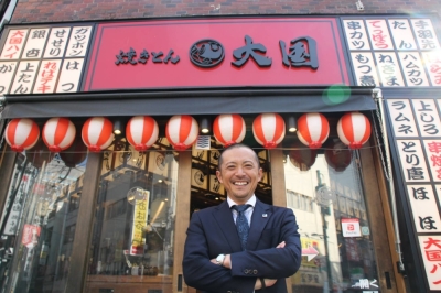 M-Sys President Masao Takikawa stands in front of a Yakiton Daikoku izakaya pub that opened in Sendai's Kokubuncho entertainment district.