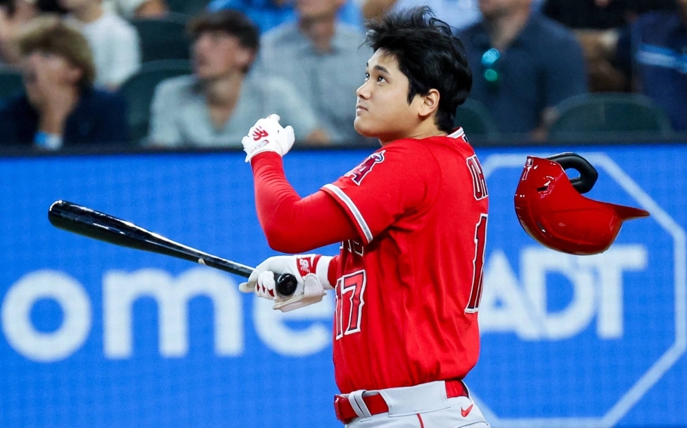 Shohei Ohtani homers as his helmet falls off during the first inning of the Angels' win over the Rangers in Arlington, Texas, on Sunday.