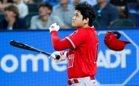 Shohei Ohtani homers as his helmet falls off during the first inning of the Angels' win over the Rangers in Arlington, Texas, on Sunday. | USA TODAY / VIA REUTERS