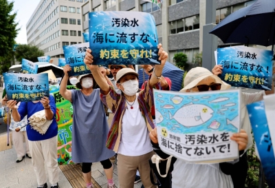Protesters shout slogans and raise banners reading "Don't throw polluted water into the sea! Keep your promises" during a rally against Japan's plan to discharge treated radioactive water from the tsunami-wrecked Fukushima plant into the ocean, in front of the Prime Minister's Office in Tokyo on Friday.