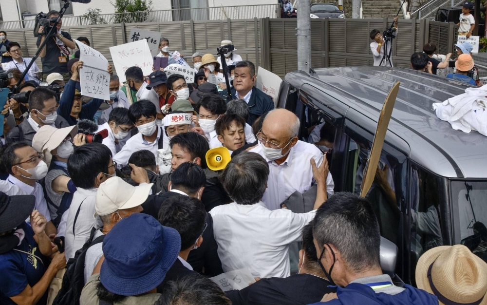 Tesuo Nishi, mayor of Kaminoseki in Yamaguchi Prefecture, is surrounded by people protesting against the construction of an interim storage facility for spent nuclear fuel in the town in front of the town office on Friday.