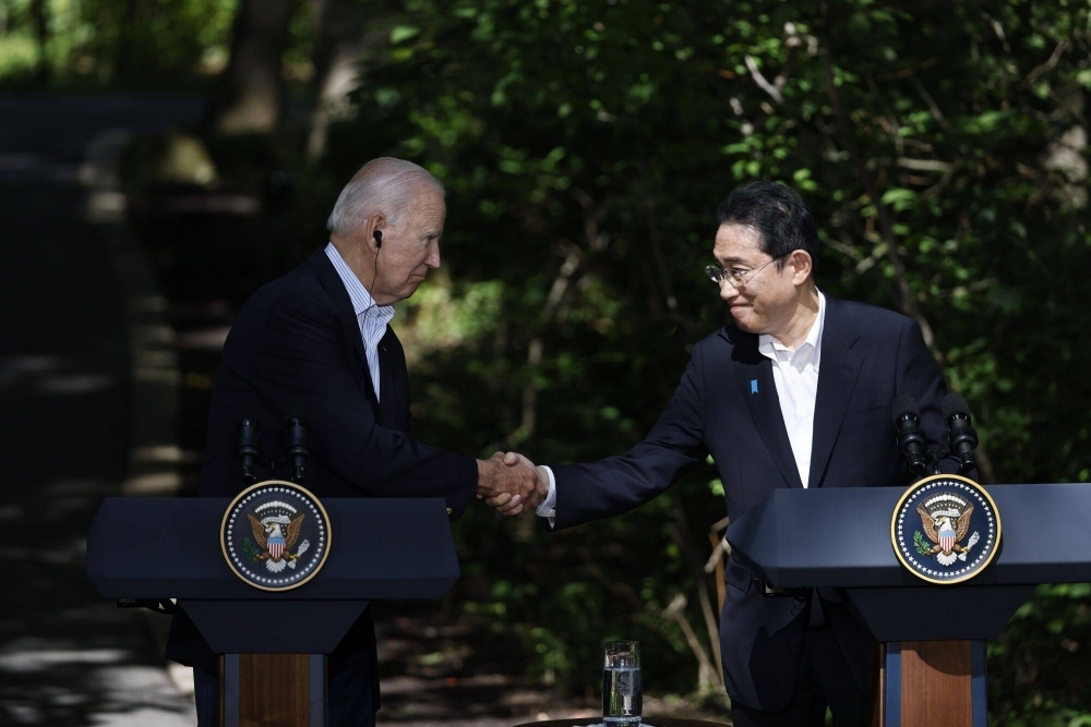 U.S. President Joe Biden shakes hands with Prime Minister Fumio Kishida at a news conference during a trilateral summit at Camp David, Maryland, on Friday.