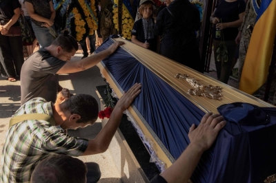Relatives and friends touch the coffin of a man who was killed fighting Russian troops in Ukraine's Donetsk region, during a funeral ceremony in Kyiv on Thursday.