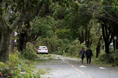 Residents walk past trees and powerlines that were downed following the passage of Hurricane Fiona, later downgraded to a post-tropical storm, in Halifax, Nova Scotia, in September 2022. 