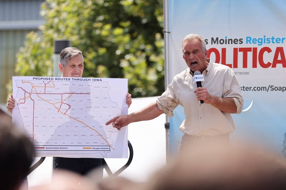 Former U.S. congressman Dennis Kucinich holds a map of a proposed carbon capture pipeline as democratic presidential candidate Robert F. Kennedy Jr. delivers a speech in Des Moines, Iowa.