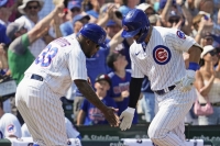 Seiya Suzuki (right) celebrates with the Cubs' third base coach after hitting his 12th homer of the season during a win over the Royals on Sunday. | AP / VIA KYODO