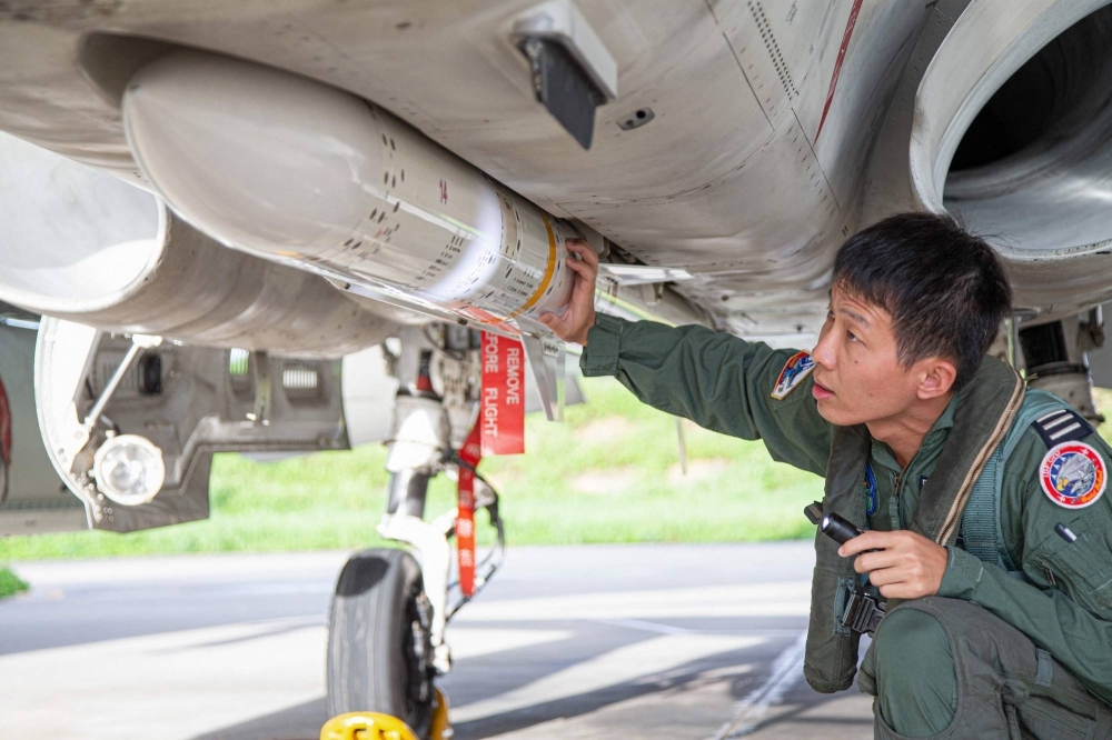 A Taiwanese air force pilot inspects ordnance on an Indigenous Defense Fighter at an undisclosed military base in Taiwan on Saturday.
