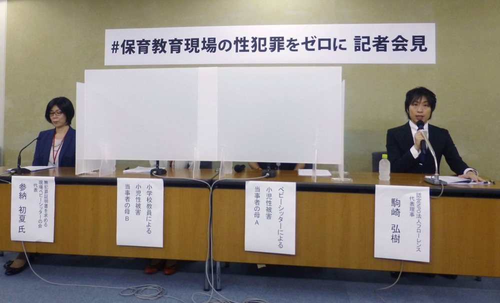 Parents of children who were victims of sex crimes hold a news conference from behind partitions in Tokyo in July 2020.