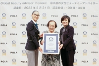 Centenarian Tomoko Horino (center) poses for a photo in Fukushima on Monday after she was recognized by Guinness World Records as the world's oldest beauty adviser. | Pola / via Kyodo