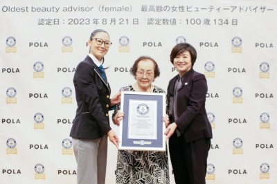 Centenarian Tomoko Horino (center) poses for a photo in Fukushima on Monday after she was recognized by Guinness World Records as the world's oldest beauty adviser.
