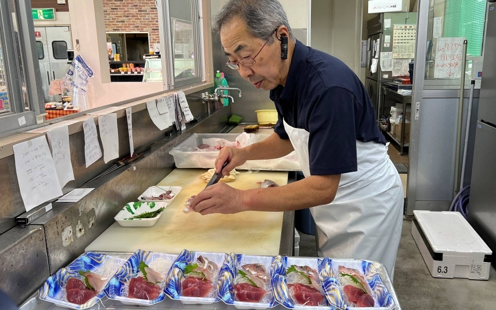 Supermarket owner Takashi Nakajima, 67, prepares raw fish to sell at his store, near the Fukushima No. 1 nuclear power plant in Soma, Fukushima Prefecture.