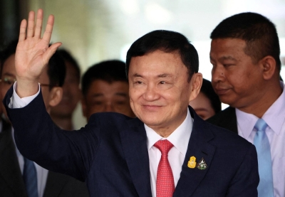 Former Thai Prime Minister Thaksin Shinawatra waves after arriving at Don Mueang airport in Bangkok on Tuesday.