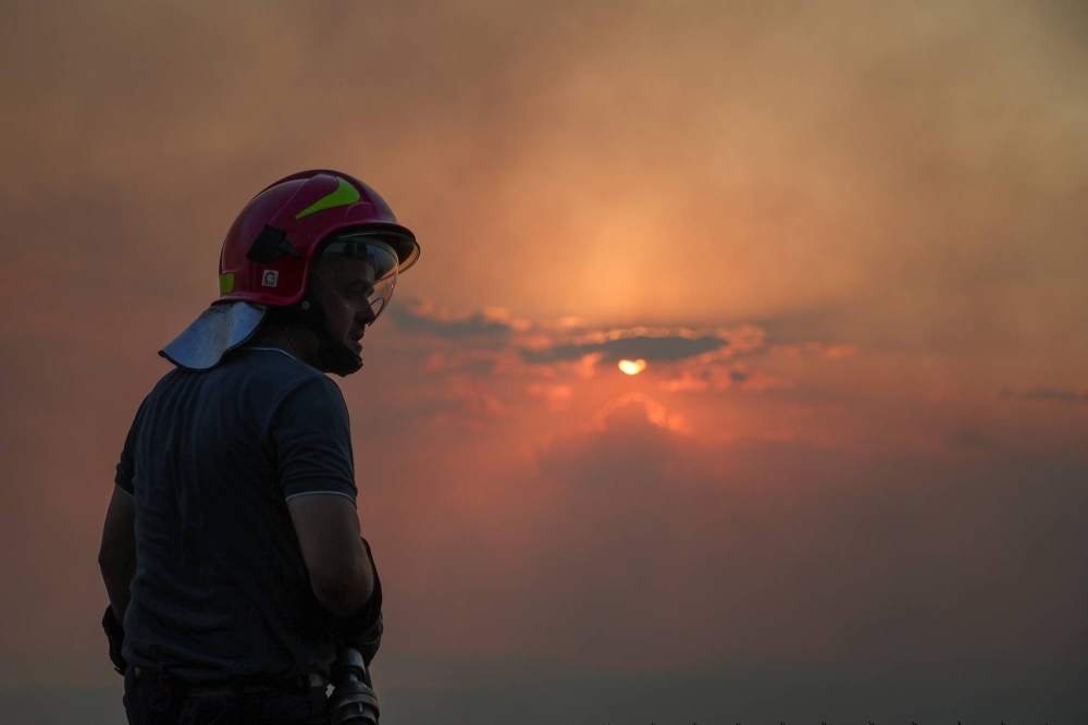 A member of emergency services looks on as a wildfire burns in Kurbin, Albania, on Tuesday.